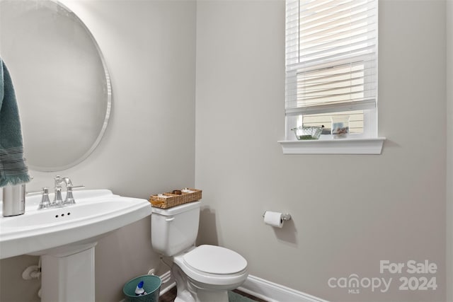 bathroom featuring plenty of natural light, toilet, and sink