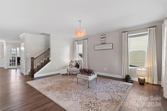 living area featuring dark hardwood / wood-style floors, a healthy amount of sunlight, and an inviting chandelier