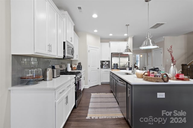 kitchen with white cabinetry, a center island with sink, decorative light fixtures, and appliances with stainless steel finishes