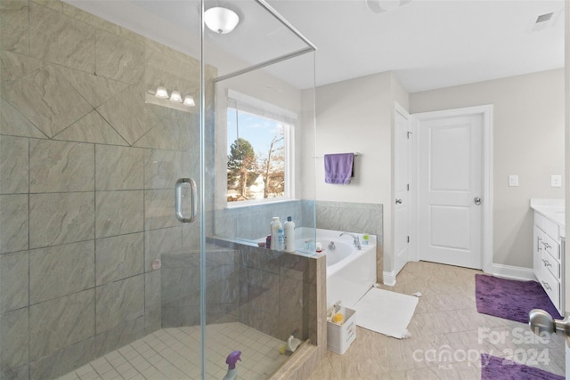 bathroom featuring plus walk in shower, vanity, and tile patterned floors