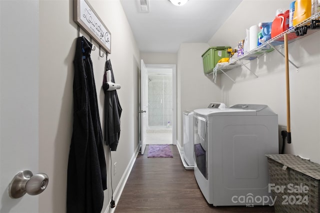 washroom with dark hardwood / wood-style flooring and washing machine and dryer