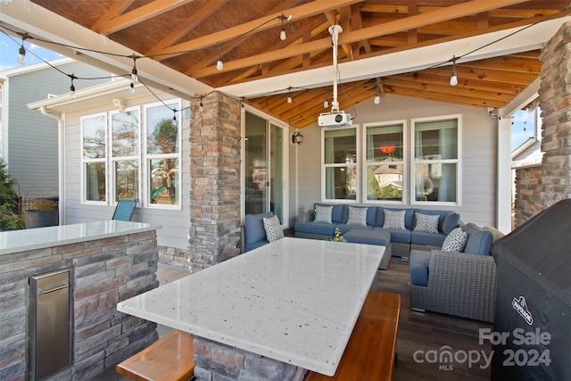 view of patio featuring a gazebo, outdoor lounge area, exterior bar, and exterior kitchen