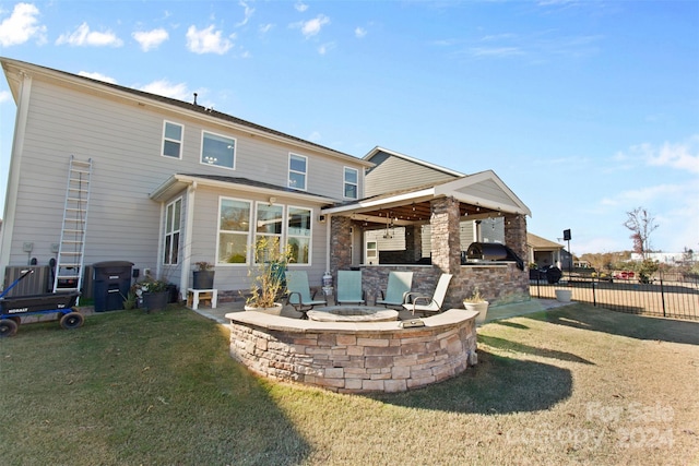 back of house featuring a lawn and an outdoor kitchen