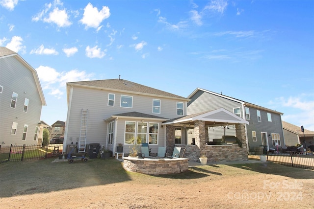 back of house with an outdoor kitchen, a patio, and a lawn