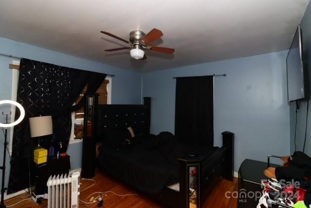 bedroom featuring radiator, ceiling fan, and dark hardwood / wood-style floors