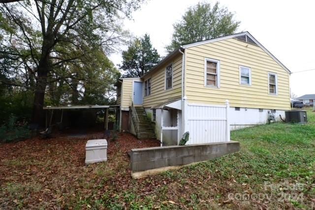 exterior space with central air condition unit and a yard