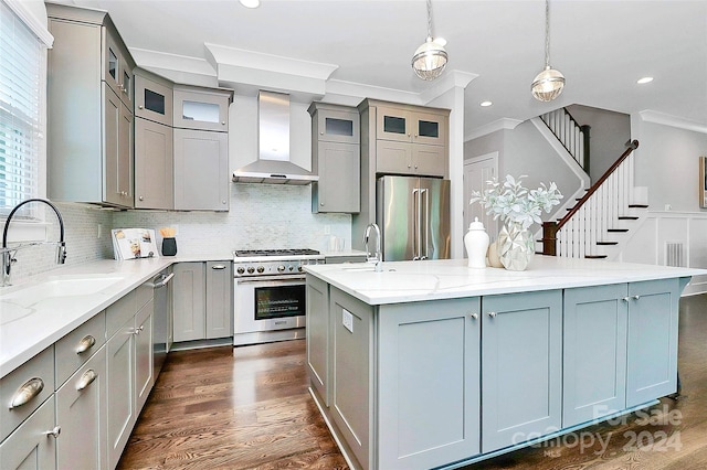 kitchen featuring crown molding, pendant lighting, wall chimney range hood, and premium appliances