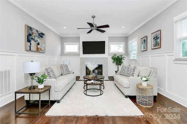 living room with plenty of natural light, a large fireplace, dark wood-type flooring, and ceiling fan