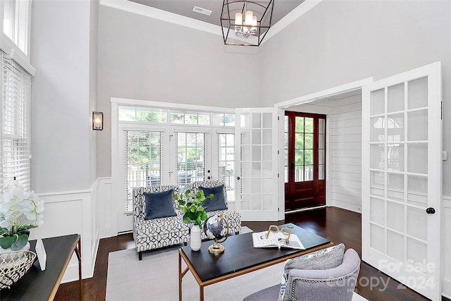 interior space with french doors, dark wood-type flooring, a high ceiling, and a notable chandelier