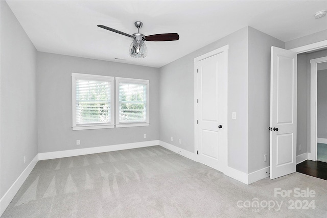 unfurnished bedroom featuring ceiling fan and light colored carpet