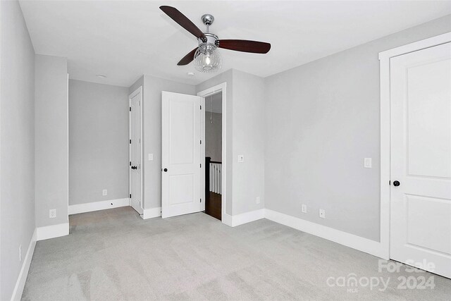 unfurnished bedroom featuring light colored carpet and ceiling fan