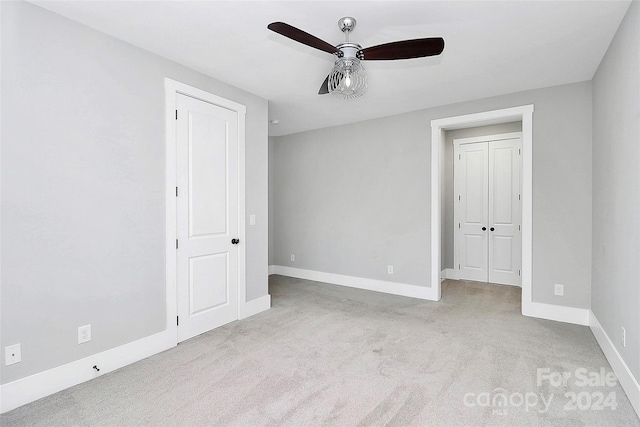 unfurnished bedroom featuring light carpet and ceiling fan