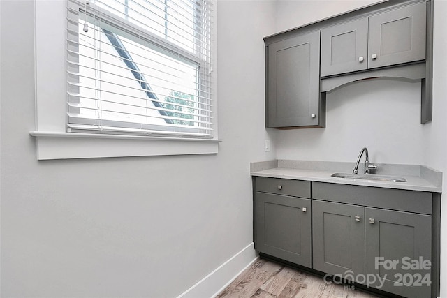 kitchen featuring gray cabinetry, sink, and light hardwood / wood-style floors