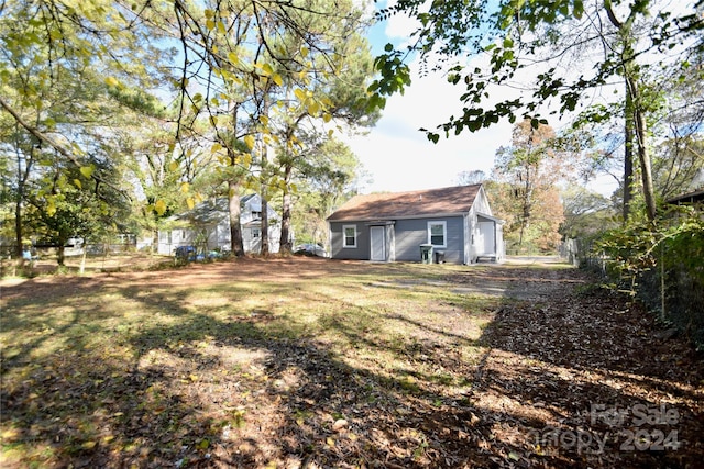 back of property featuring a yard and an outdoor structure