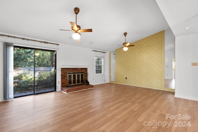 unfurnished living room with ceiling fan, light hardwood / wood-style flooring, and a brick fireplace