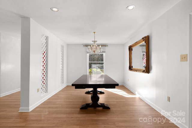 unfurnished dining area with light wood-type flooring and an inviting chandelier