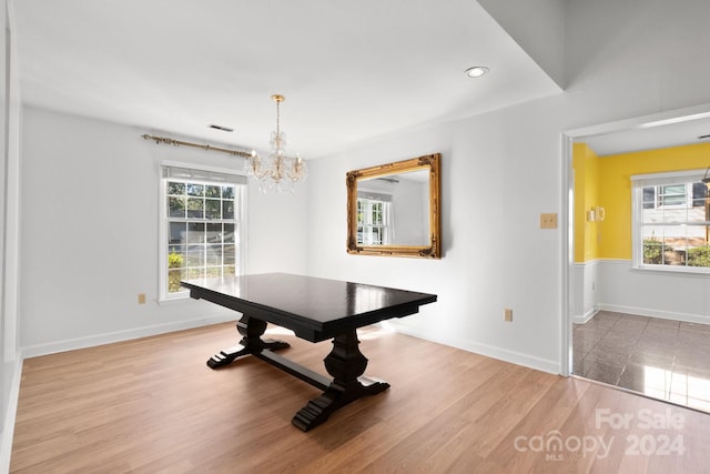 unfurnished dining area with an inviting chandelier, a healthy amount of sunlight, and light wood-type flooring