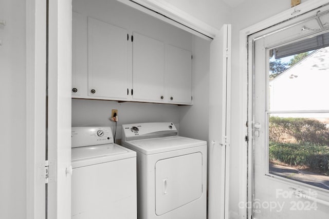 clothes washing area with cabinets and separate washer and dryer