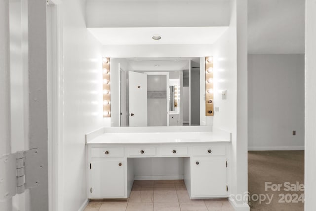 bathroom with elevator, tile patterned flooring, and vanity