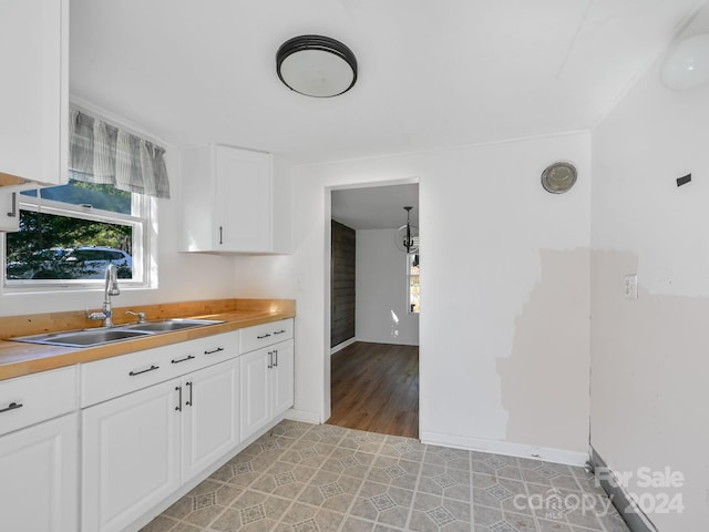 kitchen with white cabinets, light wood-type flooring, and sink