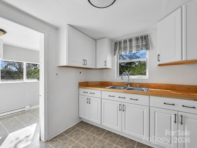 kitchen with a healthy amount of sunlight, white cabinetry, and sink