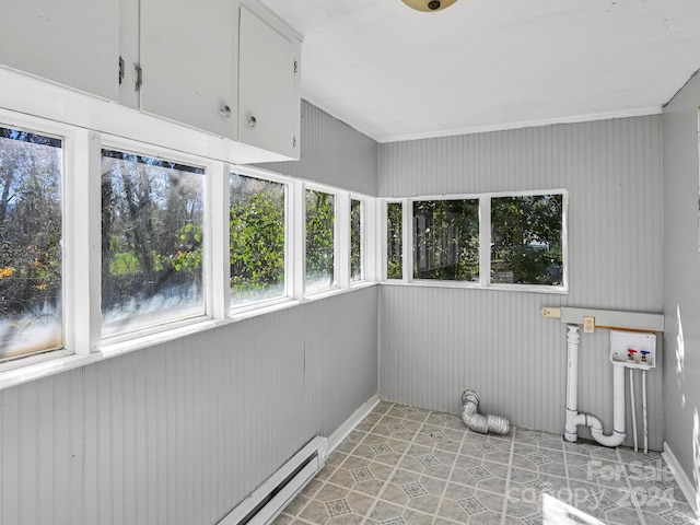 laundry room featuring wood walls, hookup for a washing machine, cabinets, and a baseboard radiator