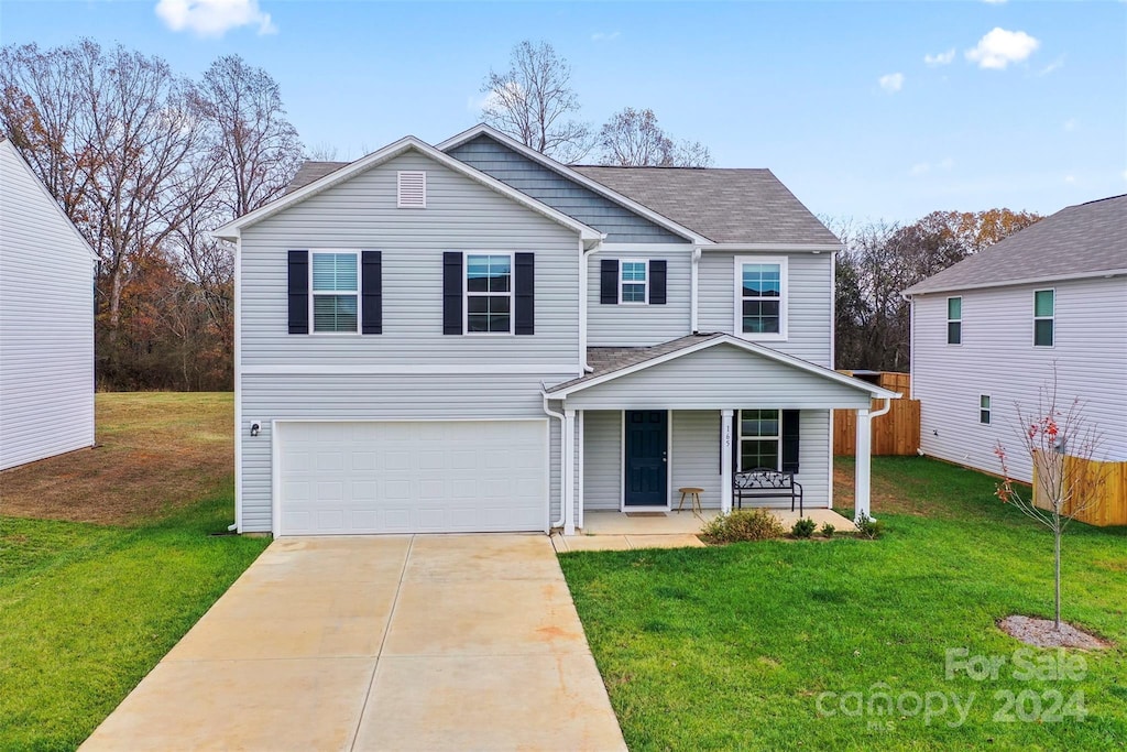 front of property with a garage, covered porch, and a front lawn