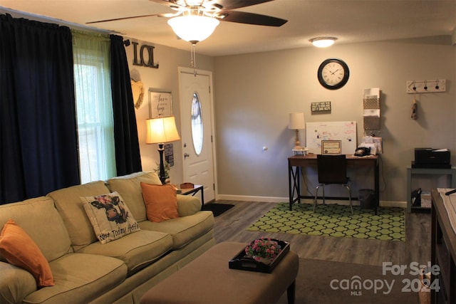 living room featuring ceiling fan and dark wood-type flooring