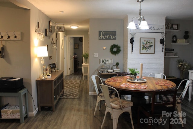 dining area featuring dark hardwood / wood-style flooring and an inviting chandelier