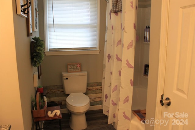 bathroom with curtained shower, wood-type flooring, and toilet