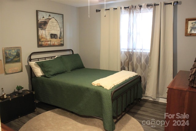 bedroom with dark hardwood / wood-style flooring