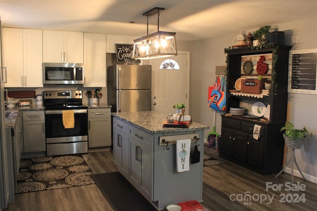 kitchen featuring appliances with stainless steel finishes, dark hardwood / wood-style flooring, gray cabinets, and pendant lighting