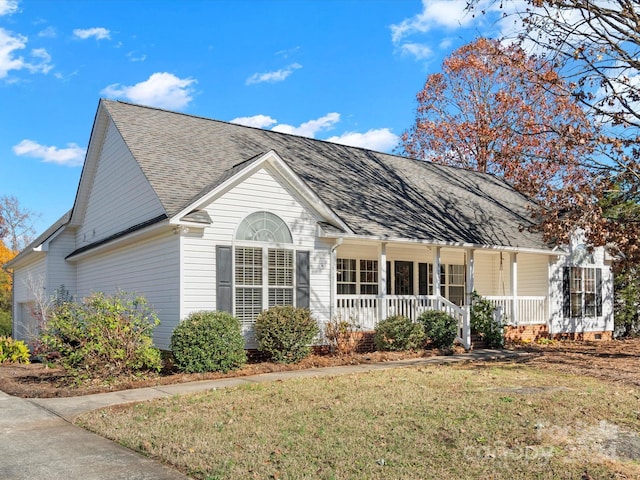 ranch-style home featuring covered porch and a front lawn