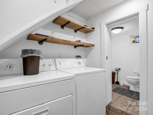 clothes washing area with washing machine and dryer and light tile patterned floors