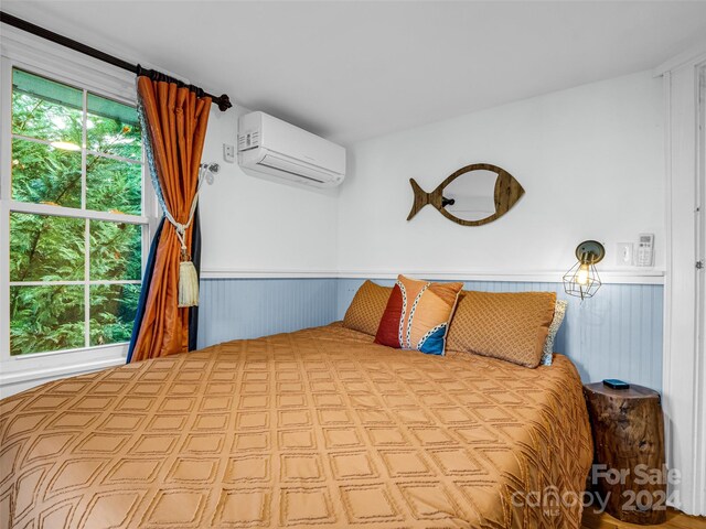 bedroom with an AC wall unit and wooden walls