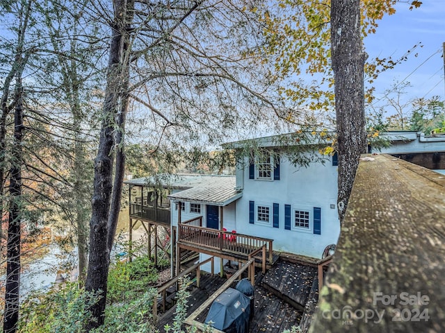 291 Tryon Bay Cir, Lake Lure, NC 28746 - back of property with a wooden deck, a metal roof, stairs, a sunroom, and stucco siding