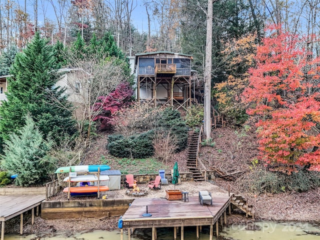 view of yard with a deck with water view and a dock