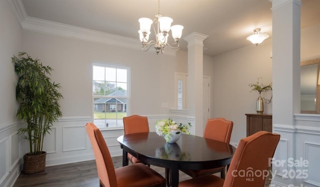 dining space with an inviting chandelier, crown molding, dark hardwood / wood-style floors, and decorative columns