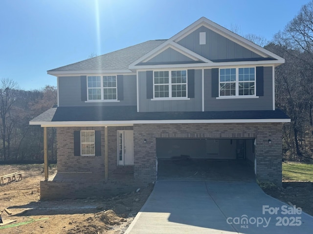 view of front of property with driveway, an attached garage, board and batten siding, and brick siding