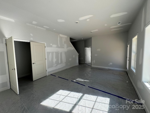 unfurnished room featuring baseboards and visible vents