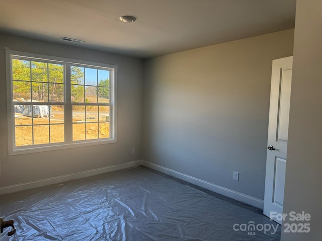 unfurnished room featuring baseboards and visible vents