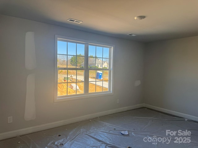 spare room featuring visible vents and baseboards