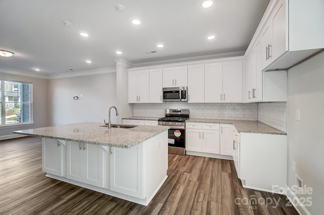 kitchen with an island with sink, white cabinetry, appliances with stainless steel finishes, and a sink