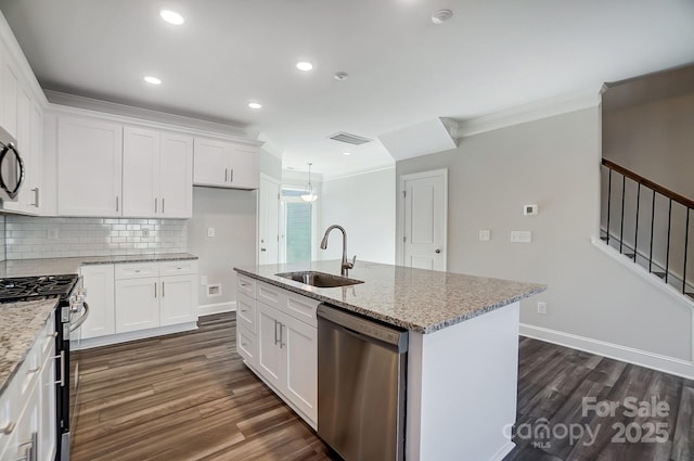 kitchen featuring appliances with stainless steel finishes, a kitchen island with sink, white cabinetry, and a sink