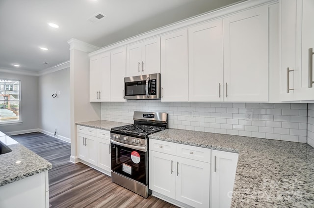 kitchen featuring stainless steel appliances, white cabinetry, crown molding, and light stone countertops