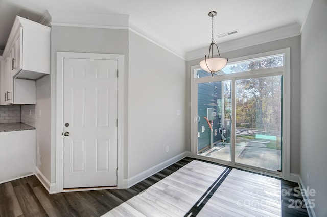 dining space featuring ornamental molding, dark wood-style flooring, visible vents, and baseboards