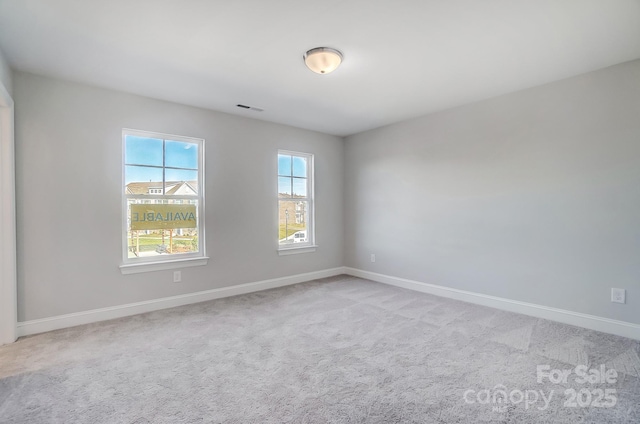 unfurnished room featuring light carpet, visible vents, and baseboards