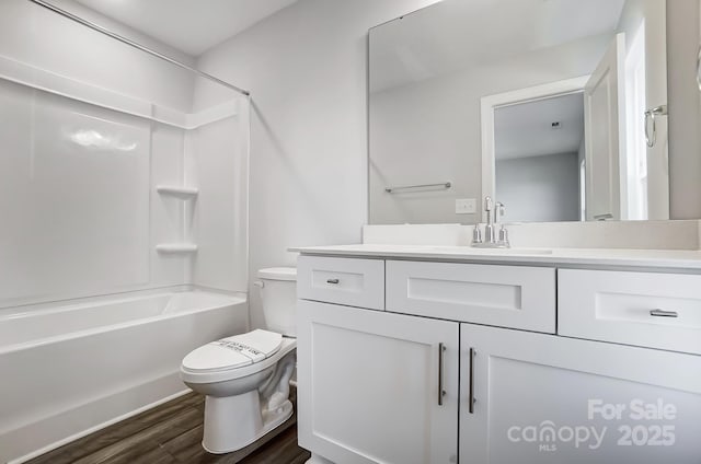 full bathroom featuring toilet, vanity, wood finished floors, and washtub / shower combination