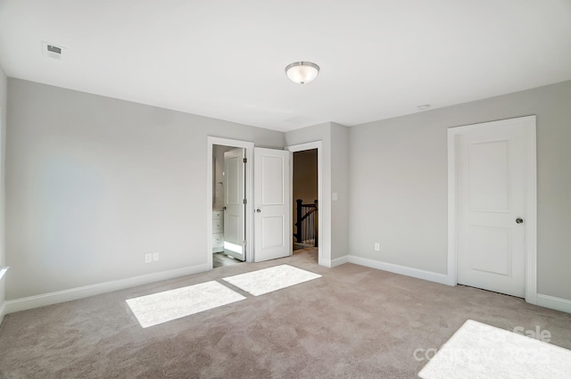 unfurnished bedroom with light carpet, baseboards, and connected bathroom