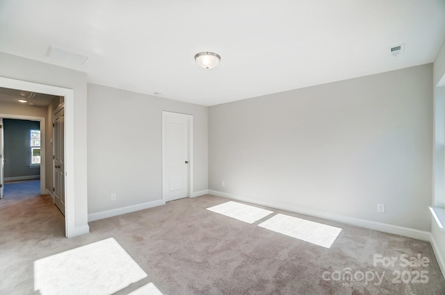 unfurnished bedroom featuring light carpet, baseboards, and visible vents